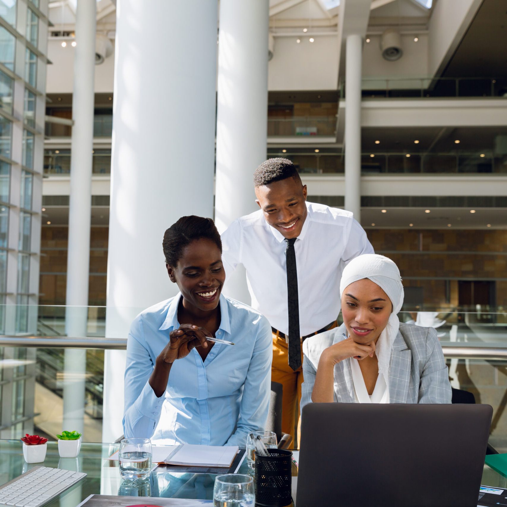 Male and females executives discussing over laptop at desk in office. Modern corporate start up new business concept with entrepreneur working hard